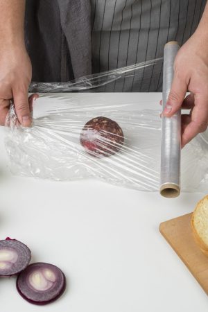 hands packing onion with plastic foil Merca2.es