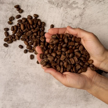 top view person holding roasted coffee beans Merca2.es