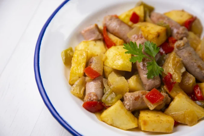 braised pork sausages with potatoes peppers traditional spanish tapa Merca2.es