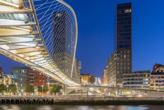 bridge that crosses bilbao estuary spain with two office skyscrapers city center Merca2.es