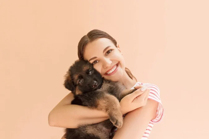 Young Woman Enjoys Hugging Small Cute Puppy